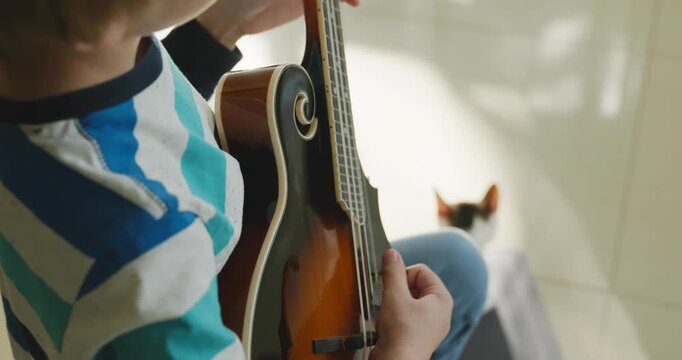 Caucasian Kid Play Mandolin at Home. European Boy Practice Music 4K 10-bit