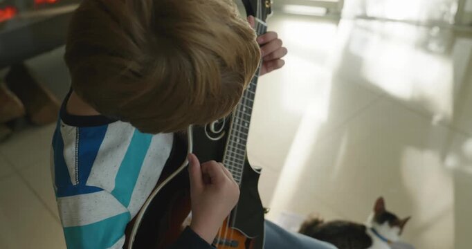Caucasian Kid Play Mandolin at Home. European Boy Practice Music 4K 10-bit