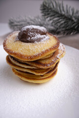 pancakes with chocolate in white plate decorated Christmas tree, delicious dessert for breakfast in winter