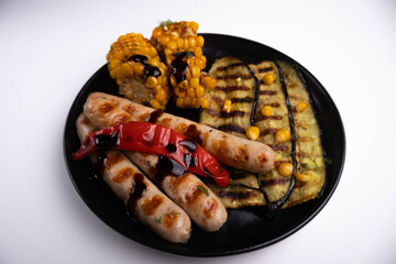 grilled vegeables and sasuage in the plate on white background