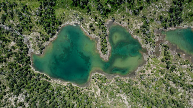 Top Down Drone View of Emerald Green Lake with Natural Shoreline