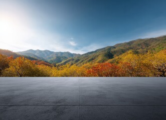 Featuring an empty concrete floor set against a vibrant, colorful autumn forest, creating an ideal backdrop for product placement and presentation