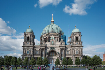 A sunny day at the Lustgarten park in front of the iconic Berlin Cathedral (Berliner Dom) on Museum Island, Germany. Tourists gather in the park to admire the historic architecture, with the Berlin TV © Peeradontax