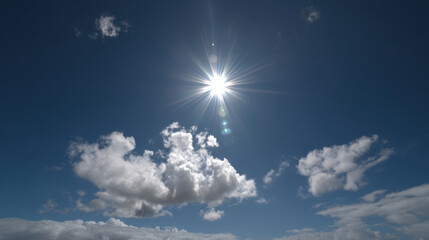 Bright sun shining in clear blue sky with fluffy white clouds scattered throughout. sunlight creates radiant effect, enhancing beauty of serene atmosphere