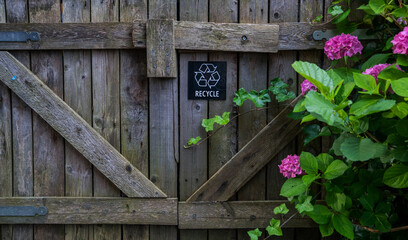 Weathered wooden garden gate with diagonal support beams and a 