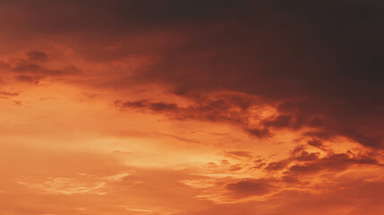 Obraz premium Stunning sunset sky filled with vibrant orange and red hues, showcasing dramatic cloud formations that evoke sense of tranquility and awe