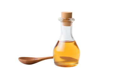 Apple cider vinegar bottle with wooden spoon  isolated on white background
