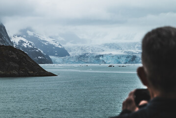 Fototapeta premium Close up view on the glaciers in Alaska, mountains and glacier landscape. Man taking photo of the glacier