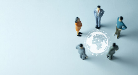 Miniature business people in a meeting around a virtual globe network. A concept for global business, international strategy, globalization, worldwide teamwork, and corporate management.