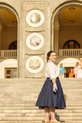 A girl stands with a suitcase in her hands on the embankment of the river station, port.