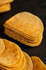 potato chips fried in oil and sprinkled with spices of dried red sweet pepper, a large number of delicious salty sweet pepper-flavored chips with aromatic spices