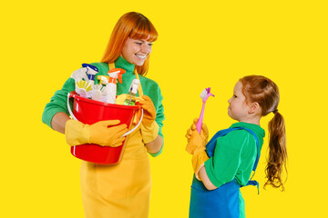 Mother and daughter cleaning together in bright colors, enjoying a fun activity with cleaning supplies on a vibrant yellow background