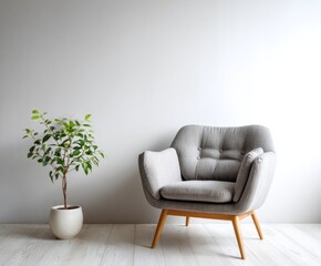 A light gray upholstered armchair sits beside a small potted plant in a minimalist interior setting.