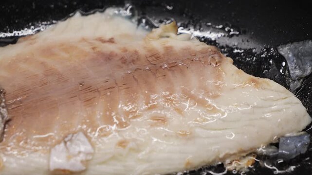 Preparing fresh fish fillet in a hot pan with oil to make a delicious meal, close-up of white fish fillet. High quality 4k footage