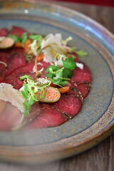 Raw beef with fresh herbs and spices on a wooden plate. Restaurant SERVING  FOOD, 