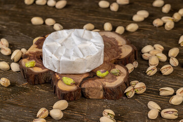 whole cheese in white mold, delicious white soft cheese in mold and a large number of salted pistachios with cracked shells.