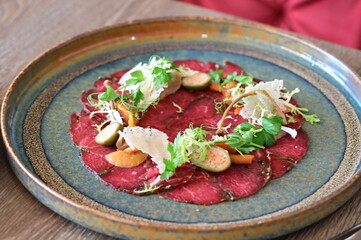 Raw beef with fresh herbs and spices on a wooden plate. Restaurant SERVING  FOOD, 