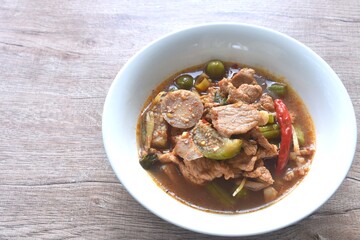 spicy boiled pork with mixed vegetable in jungle curry soup Thai food in bowl