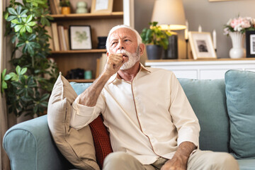 Senior, sick man and couch with chest pain on sofa for cardiac arrest or bronchitis at home....