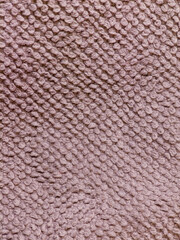Fototapeta premium Close up of textured pink knit fabric showing looped yarn pattern