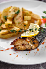 Grilled fish with lemon and herbs served with roasted potatoes.