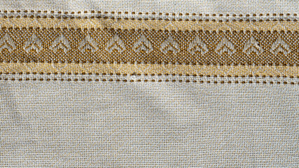 a textured fabric featuring intricate, floral embroidery. The overall style is traditional and...