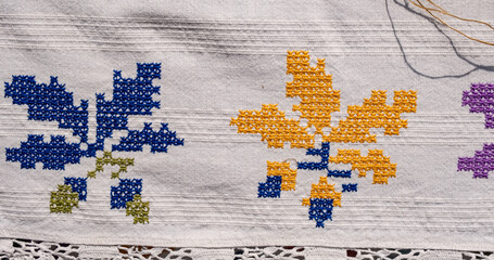 a textured fabric featuring intricate, floral embroidery. The overall style is traditional and...