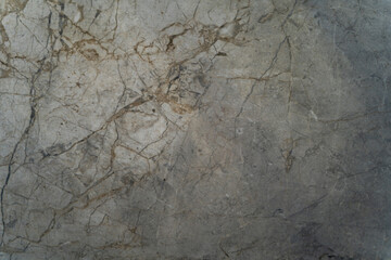 Textured gray marble surface features intricate veining patterns, highlighting the natural beauty of stone, perfect for backgrounds in interior design and artistic projects