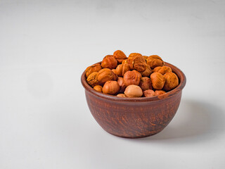 Raw hazelnuts without shells in a bowl on a white background
