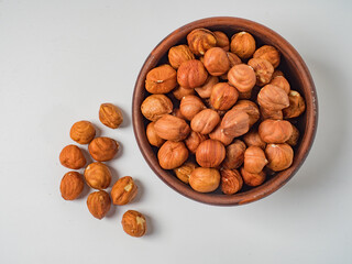 Raw hazelnuts without shells in a bowl on a white background
