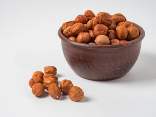 Raw hazelnuts without shells in a bowl on a white background
