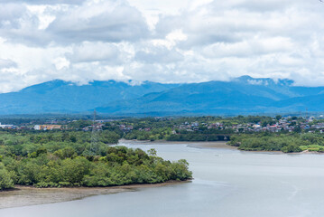 Lush green riverbanks near Buenaventura, Colombia, with dense tropical vegetation. 