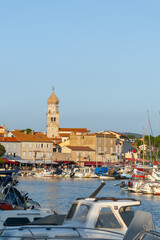 Krk old town with bell tower and harbor view. Mediterranean heritage, summer tourism, and historical architecture