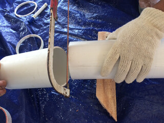 hand cutting pvc pipe with a hacksaw