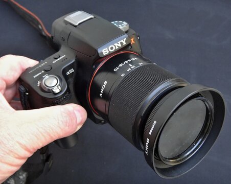 Photographer holding Sony a55 camera with lens hood