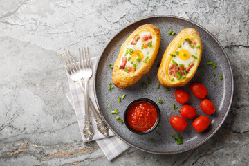Egg Stuffed Baked Potatoes closeup on the plate on the table. Horizontal top view from above