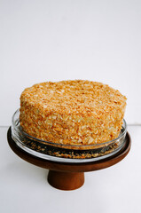 Delicious homemade cake topped with crunchy oatmeal layer displayed on wooden stand