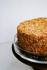 Delicious layered cake with a crunchy topping on a cake stand at a cozy kitchen setting