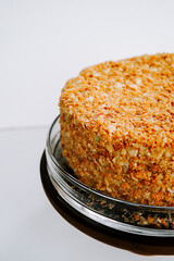 Delicious layered cake topped with crunchy almonds on a glass serving plate