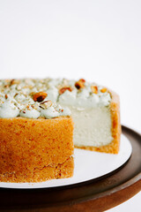 Delicious creamy cake with a crunchy crust and decorative toppings on a wooden tray