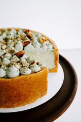 Creamy dessert with mint and pistachio decorations on a wooden platter offered in a bakery
