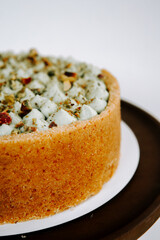 Delicious layered cake with nuts and creamy topping, beautifully presented on a plate