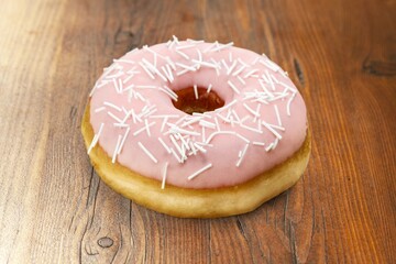 Tasty sweet fresh Donut with sprinkles on desk