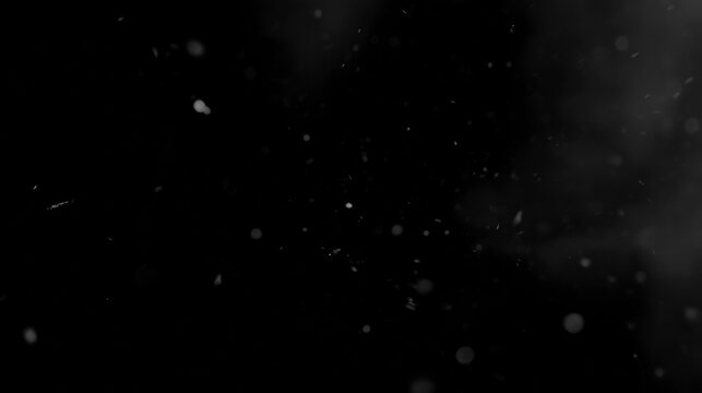White particles floating on black background