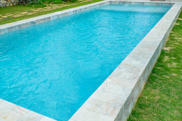 Empty swimming pool with sunbed and white umbrella in resort hotel for vacation leisure and white sand,resort neary sea and beach in summer.