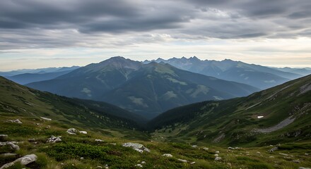 Naklejka premium Mountain Range with Lush Valley and Overcast Sky