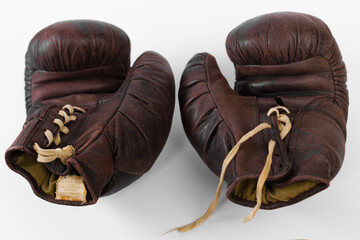 Vintage boxing gloves resting on a flat surface showcasing craftsmanship and wear from past matches