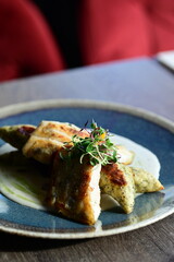 Crispy fried fish fillet with sauce on a blue plate