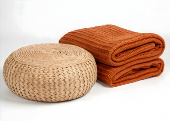 Woven ottoman and folded blankets provide a cozy and inviting home decor arrangement