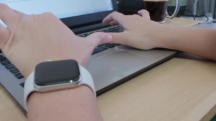 Hands typing on a laptop, essential tools for a digital nomad working remotely from any location.